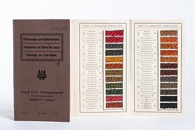 Aufgeschlagene Farbmusterkarte mit Färbungen auf Kokosfaser der Kalle und Co. AG, Biebrich am Rhein.